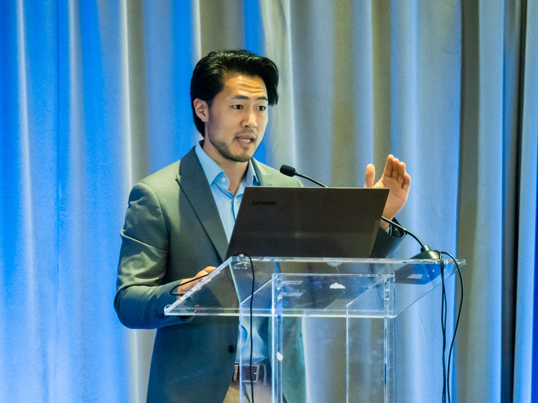 Brian Kim presenting at a conference podium